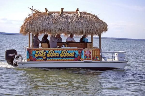 a boat with a tiki hut on a body of water