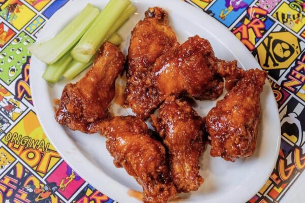 a plate of buffalo wings with vegetables on the side